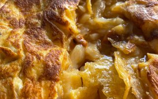 La tortilla, recién cuajada con el interior fluido, la patata crujiente, la patatera fundida y el bacalao en su punto